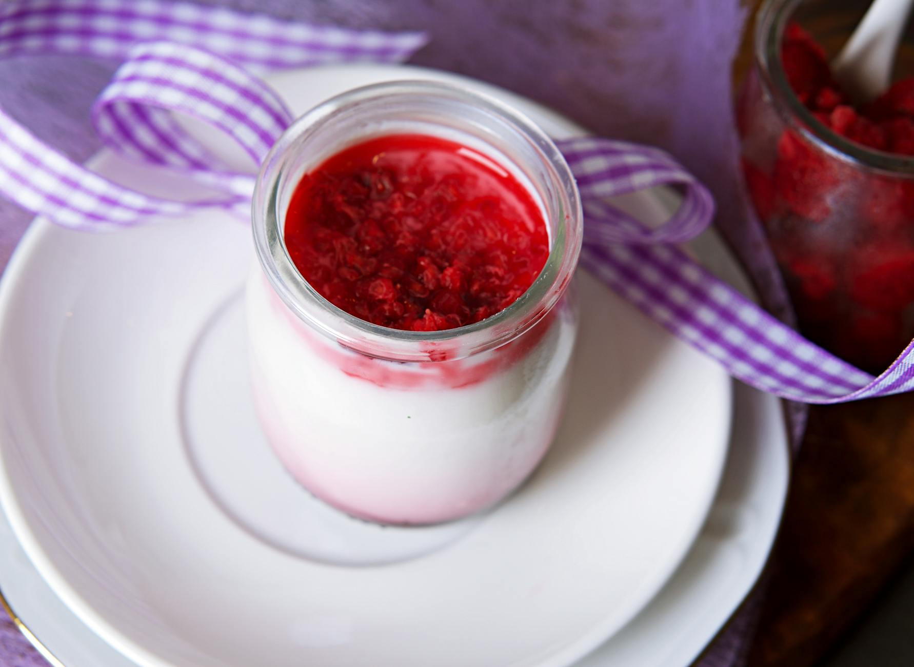 Panna cotta w słoiczku z malinami jako słodki deser na przyjęcie
