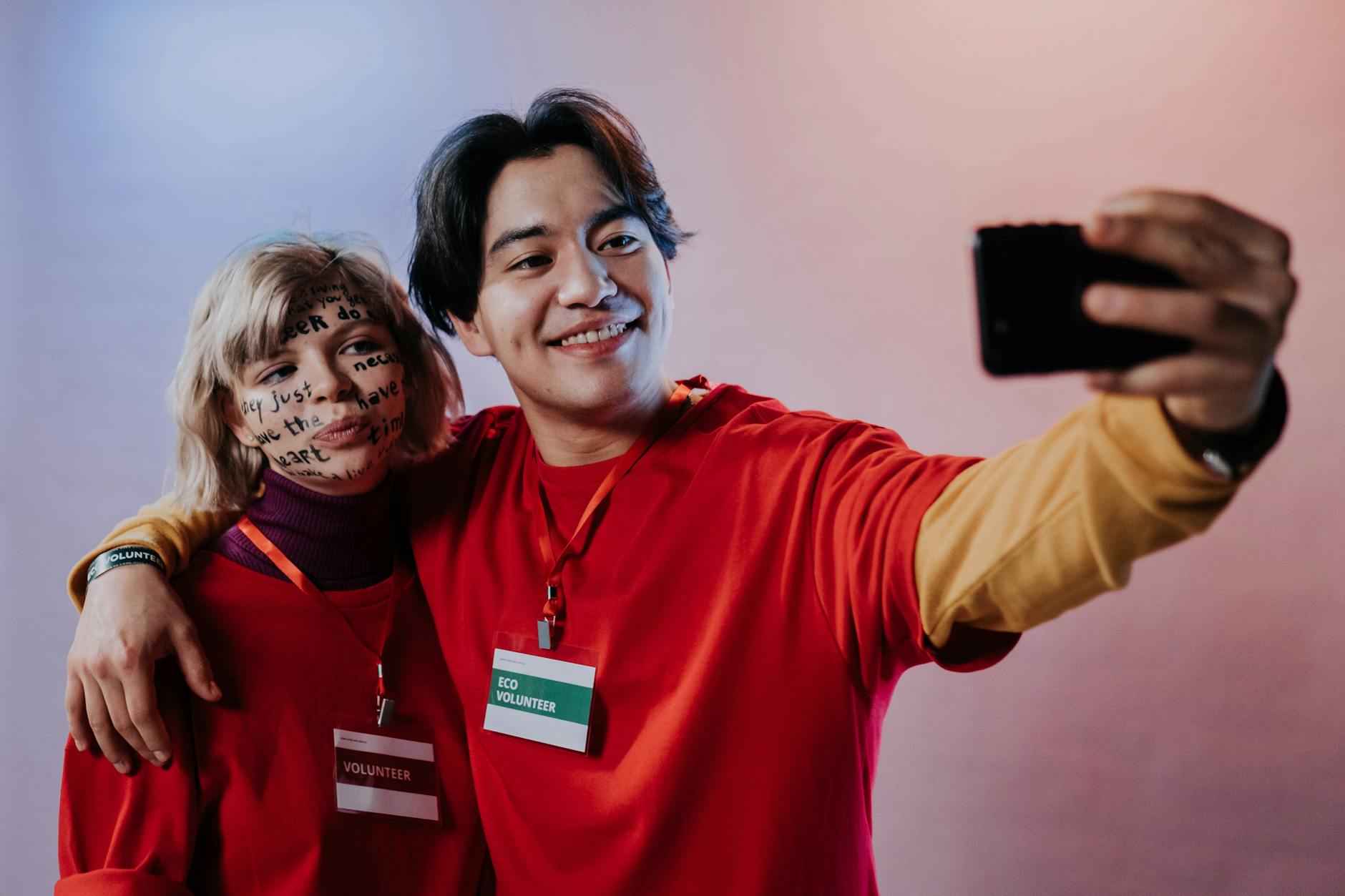Uśmiechnięci wolontariusze robią selfie podczas pracy charytatywnej