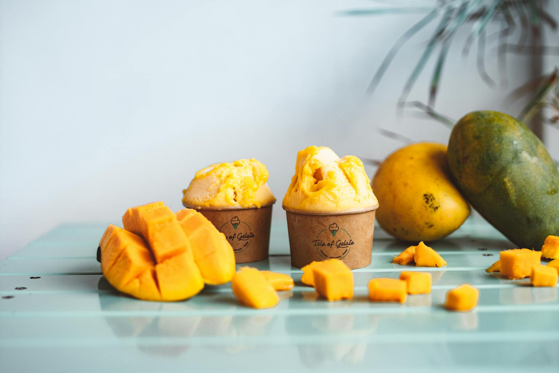 Domowe mango gelato w kubeczkach z plasterkami świeżego mango