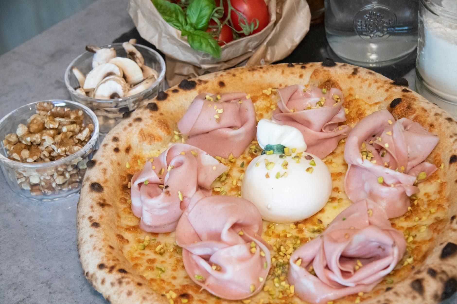 Pizza neapolitańska z mortadelą, burratą i posypką z pistacji Pizza neapolitańska z mortadelą, burratą i posypką z pistacji