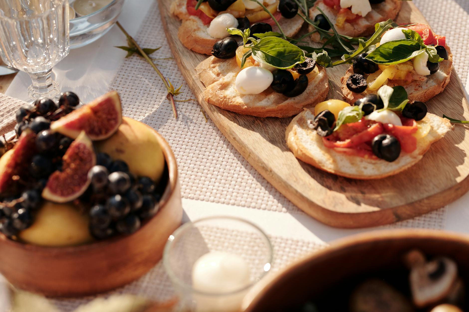 Słoneczny stół na zewnątrz z bruschettą i świeżymi owocami aperitivo