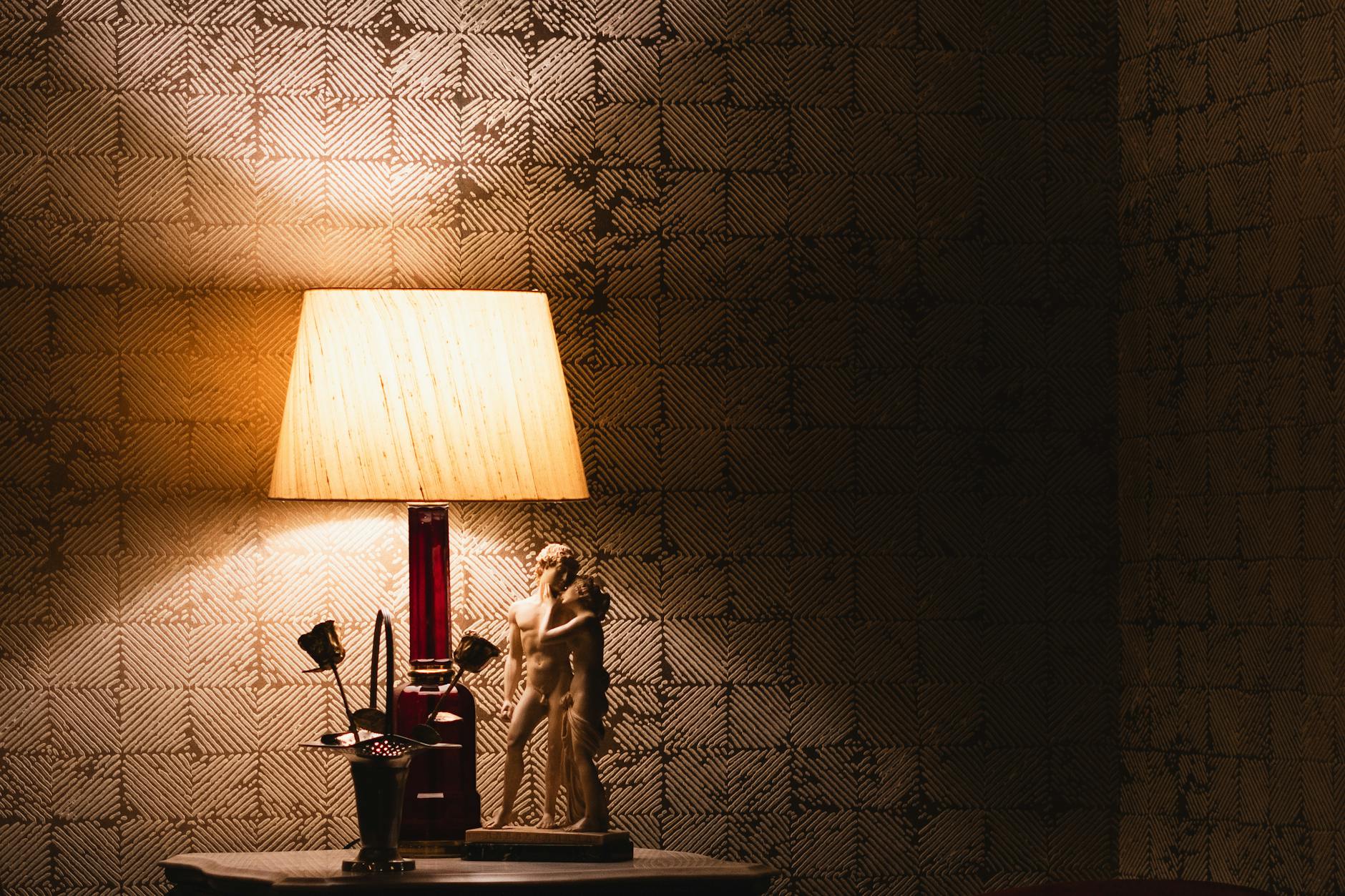 Zbliżenie włoskiej figurki i lampy stołowej w przytulnym wnętrzu vintage