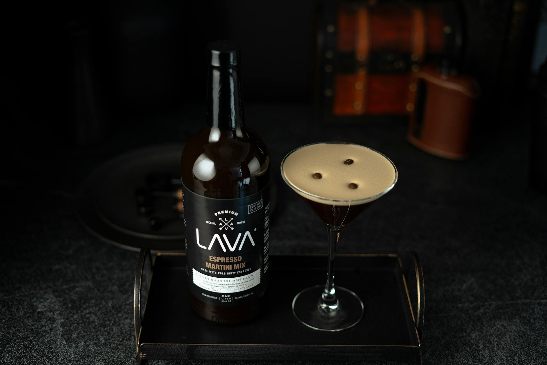 Espresso martini w kieliszku z butelką likieru na tacy Espresso martini w kieliszku z butelką likieru na tacy