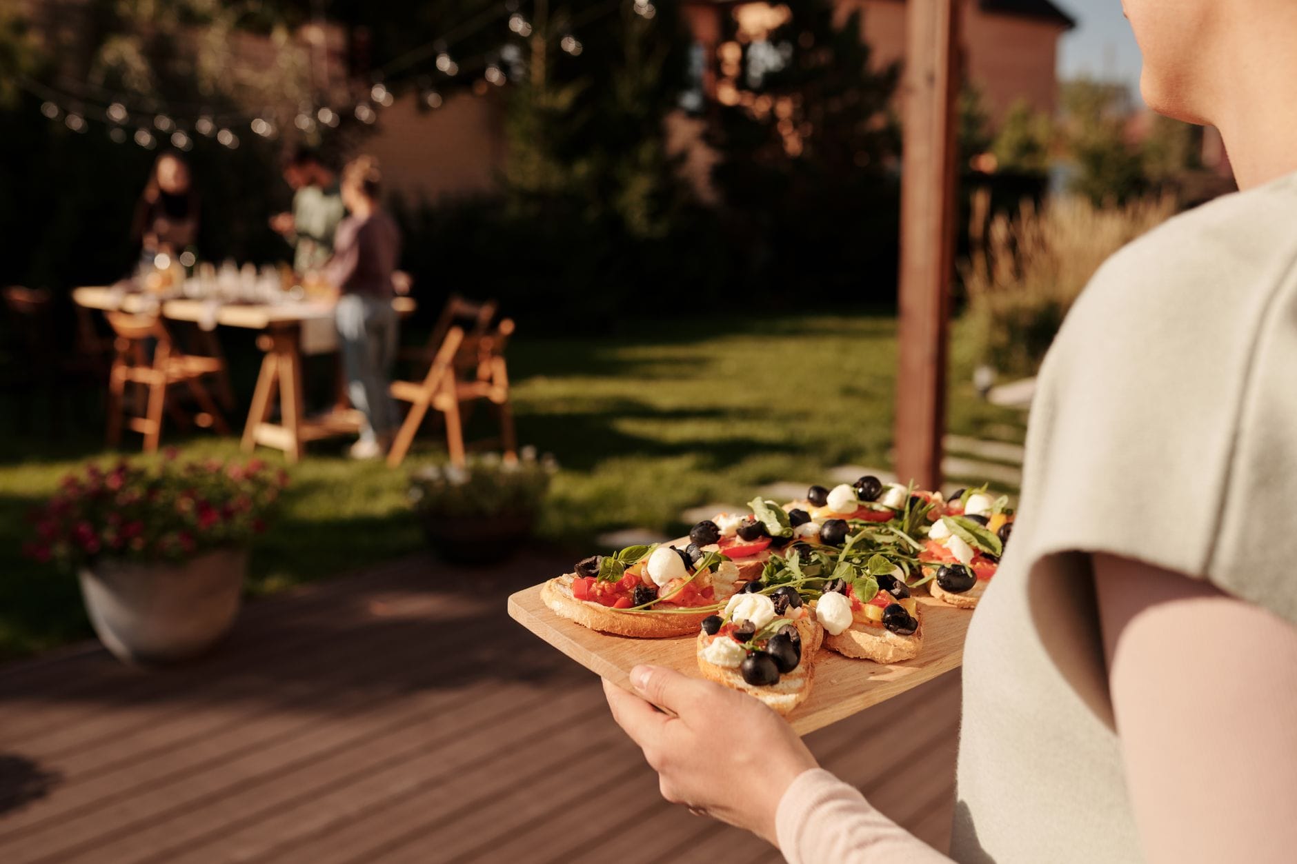 Bruschetta na aperitivo: 10 wersji od klasycznej po sezonową Kobieta podająca bruschetty na tacy podczas ogrodowego aperitivo