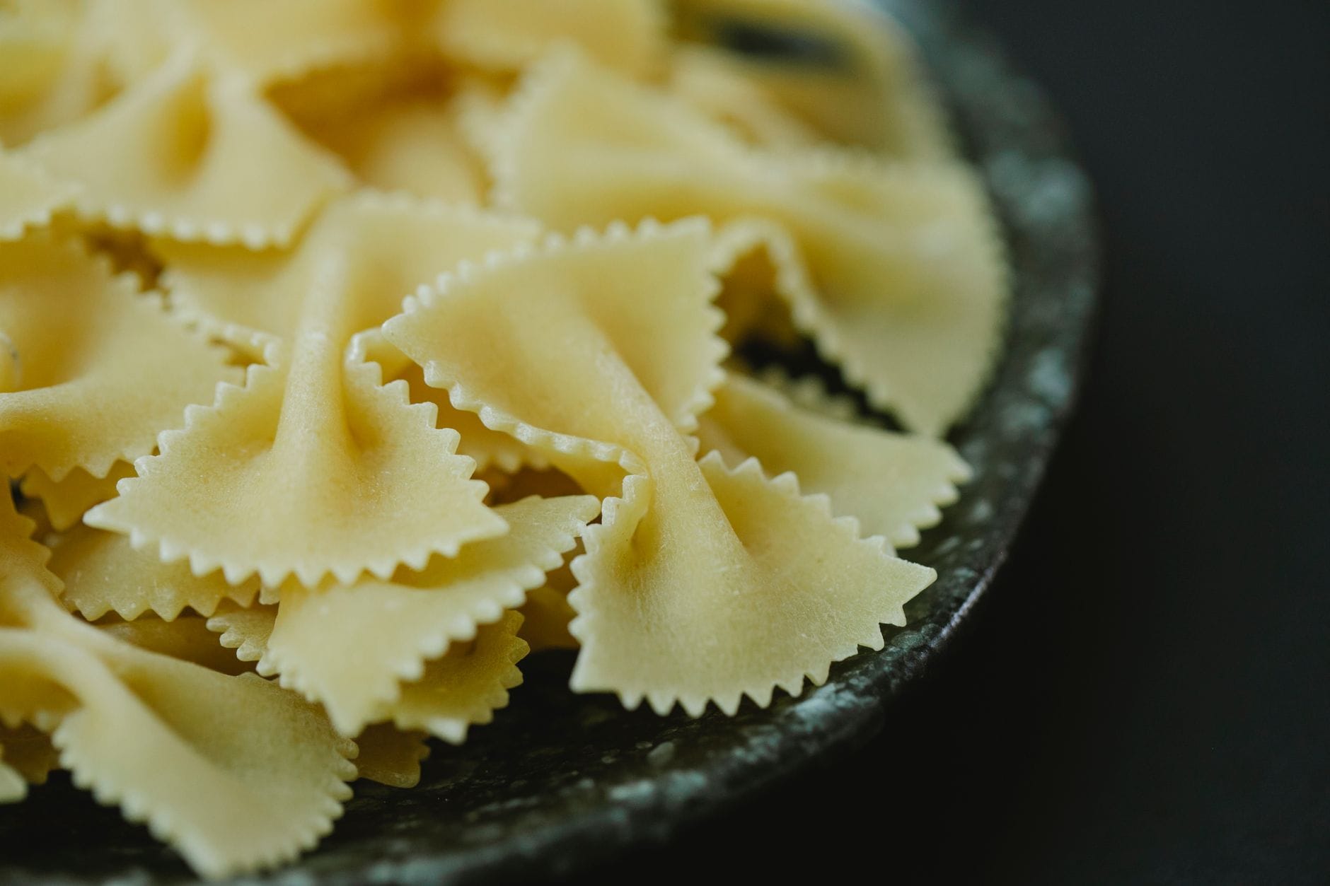 Suche muszelki farfalle w misce na ciemnym tle